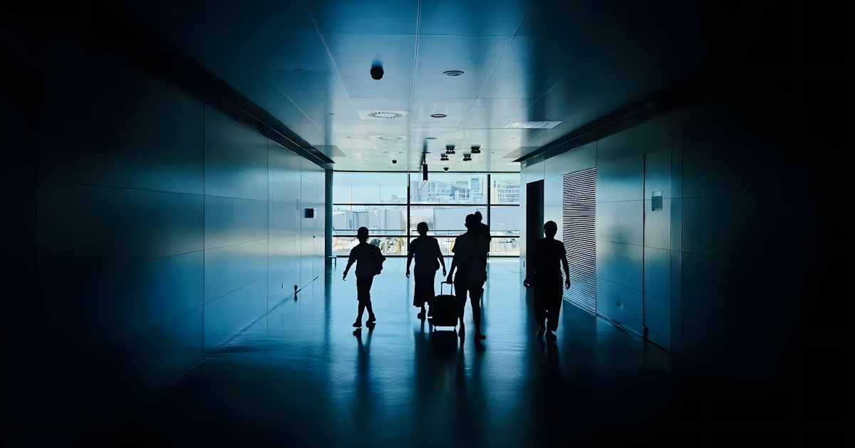 What is Money Laundering? A Beginner's Guide to How Dirty Money Becomes Clean in 2026 6 Silhouettes of people walking down a modern hallway.