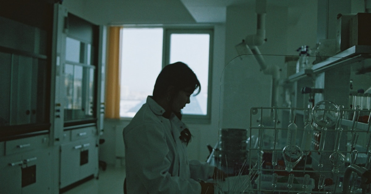 man in white dress shirt standing near window