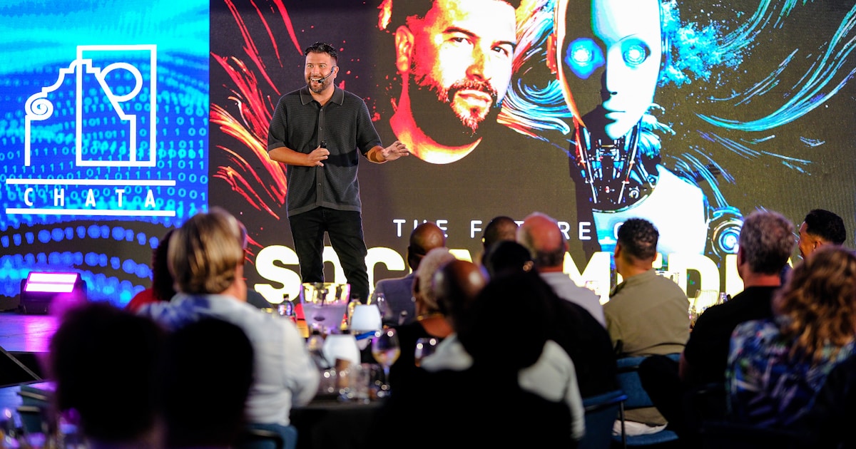 Man presents on stage with robot graphic background
