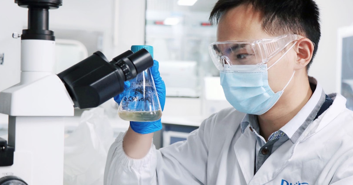 A man in a white lab coat and goggles