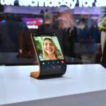 Smartphone displaying a video call on a stand.