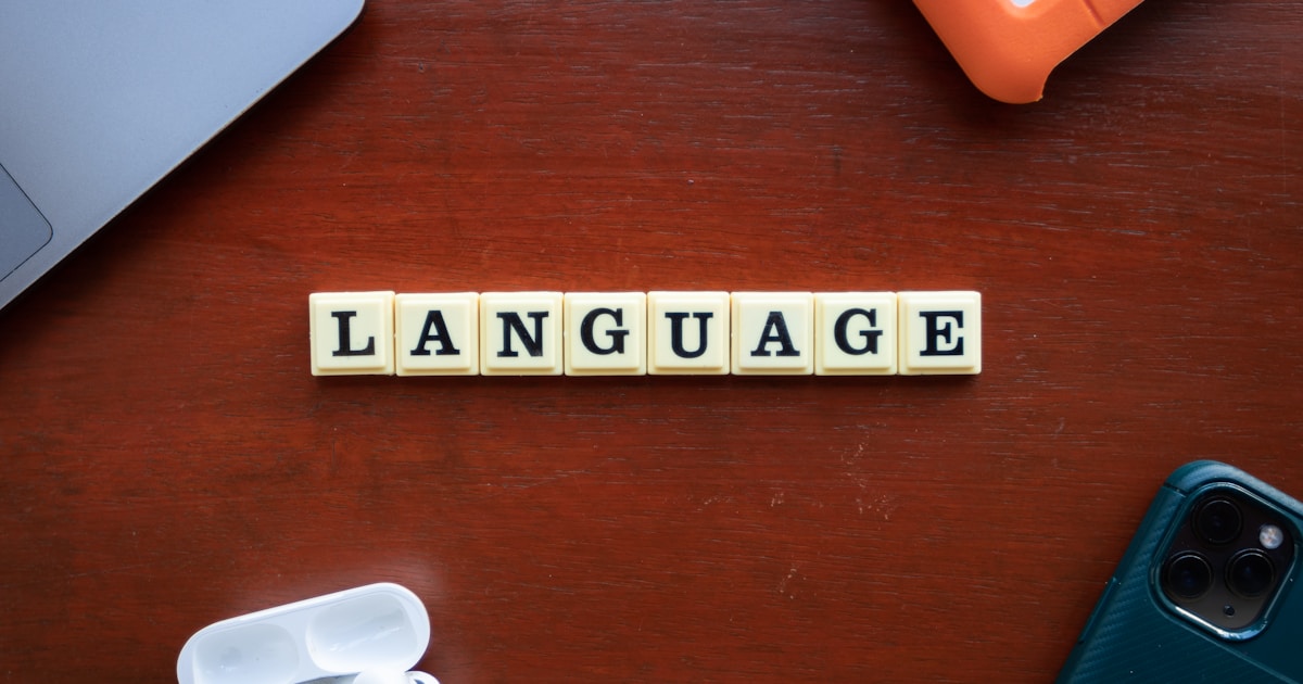 the word language spelled with scrabble tiles on a table