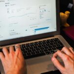 person using macbook pro on black table
