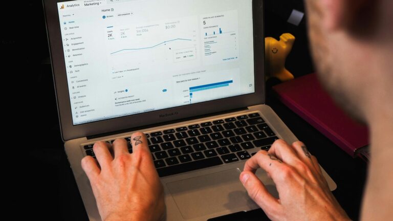 person using macbook pro on black table