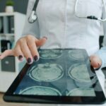 Doctor shows brain scan on tablet in office