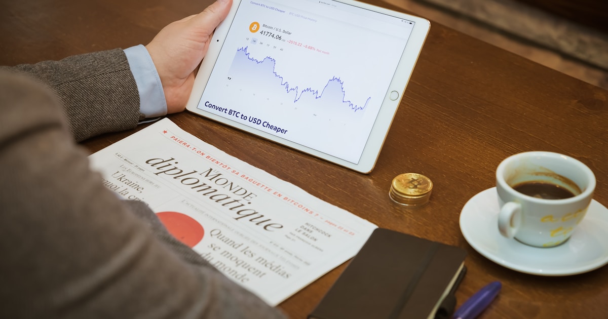 a person sitting at a table with a tablet and a cup of coffee