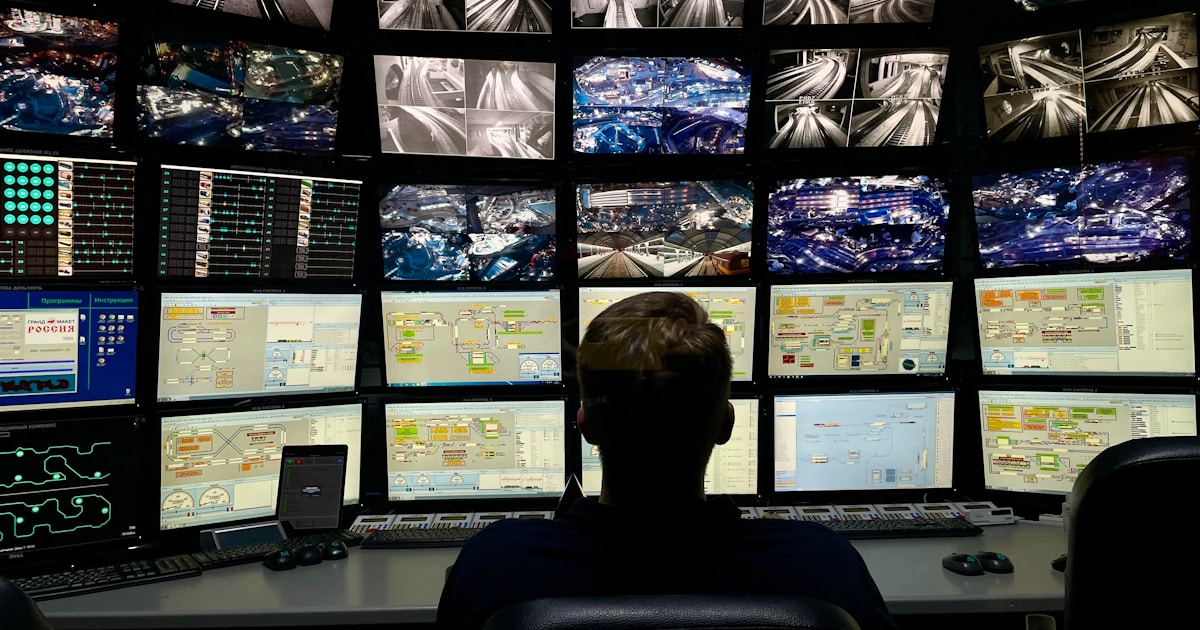 a man sitting in front of multiple monitors
