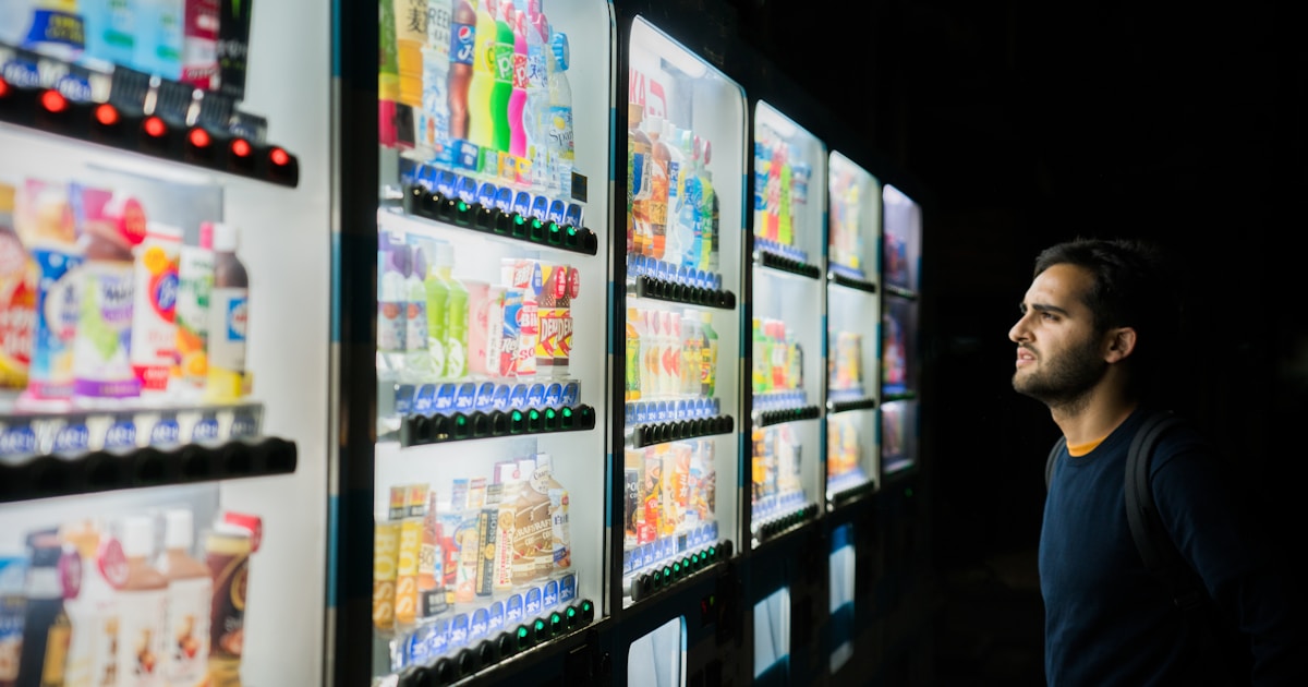 man on front of vending machines at nighttime