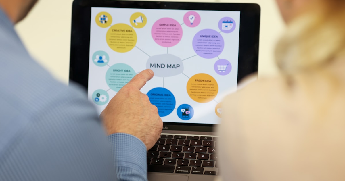 Ultimate Beneficial Ownership (UBO) Explained: How to Identify Hidden Owners and Stay Compliant 2 People are looking at a mind map on a laptop screen.